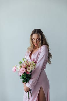 woman in a pink dress with flowers stands in a bright room