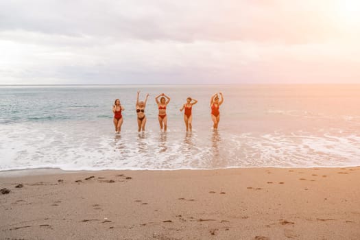 Big happy family or group of five friends is having fun against sunset beach. Beach holidays concept