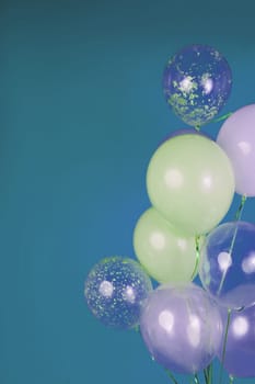 Balloons of light colors - white, light green, transparent on a blue background. High quality photo