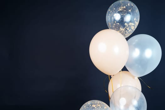 Bunch of balloons of white, beige and transparent colors on a dark background. Place for the inscription. High quality photo