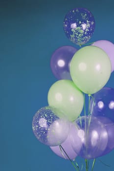 Balloons of light colors - white, light green, transparent on a blue background. High quality photo