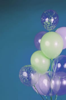 Balloons of light colors - white, light green, transparent on a blue background. High quality photo