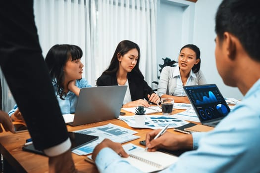 Diverse group of business analyst team analyzing financial data report. Finance data analysis chart and graph dashboard show on TV screen in meeting room for strategic marketing planning. Habiliment