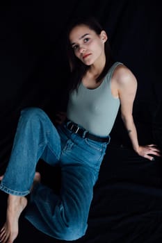 woman in jeans posing on a black background