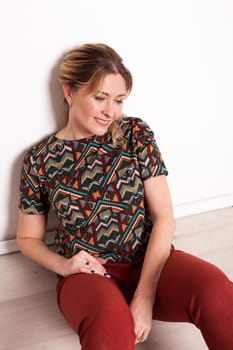 a blonde woman sitting on the floor of a room