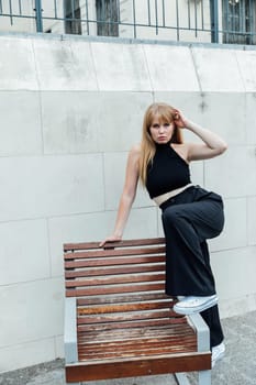 woman stands near a bench walking rest on the street