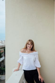 beautiful woman standing on the balcony of the room