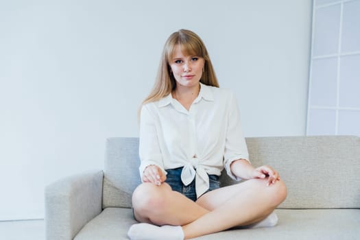 woman sitting on a sofa in a bright room