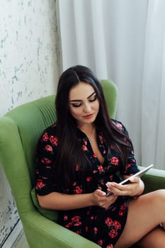 a woman brunette in chair with tablet work communication