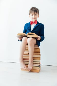 an important boy sitting on books teaching school class