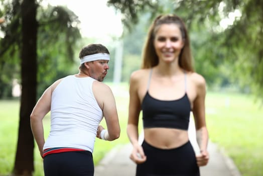 Portrait of surprised sportsman looking at wonderful bodybuilder with interest. Funny sportsperson wearing casual white fillet. Fitness and sport concept