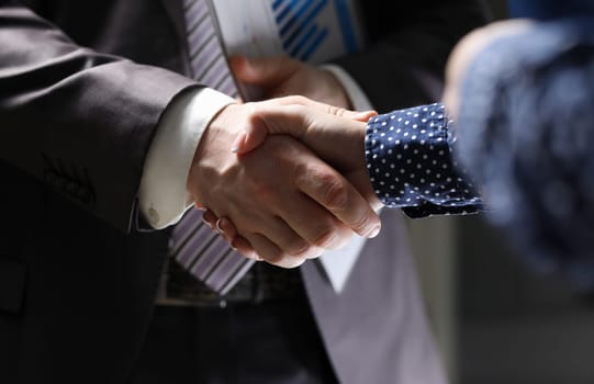Businessman and woman hand shake indoor office teambuilding background closeup. Equality business education concept