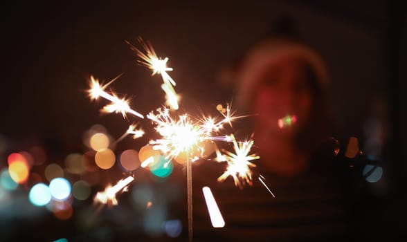 Woman hold sparklers in hand closeup. Xmas dark bacground concept