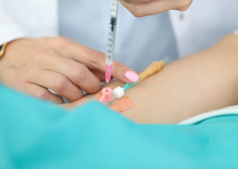 Focus on tender hands of experienced woman. Professional nurse introducing syringe with medicine in dropper in hospital. Healthcare and medicine concept