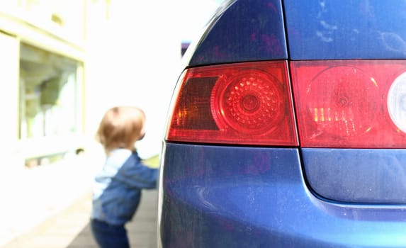 Rear left car lantern optics blue on red, small child steals car
