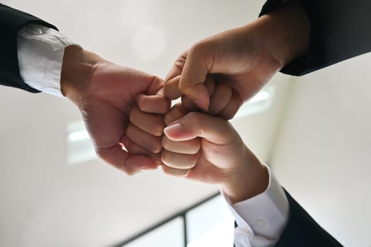 Businesspeople giving fist bump at meeting. Concept of corporate unity, motivating, solidarity, trust.