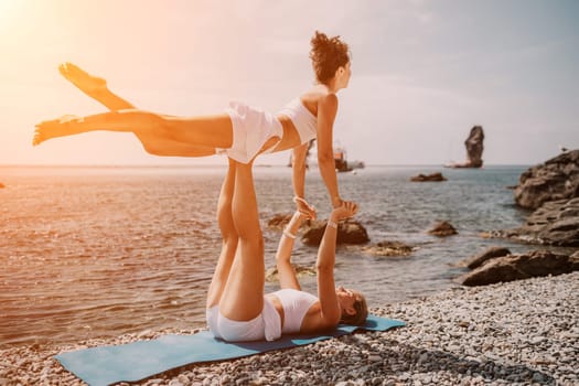 Woman sea yoga. Back view of free calm happy satisfied woman with long hair standing on top rock with yoga position against of sky by the sea. Healthy lifestyle outdoors in nature, fitness concept.