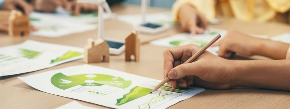 Rising graph representing the profit of using clean energy, displayed on a table at a green business meeting. Environmental documents was scattered around the table. Closeup. Delineation.