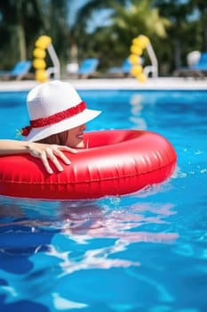 Christmas holidays on tropical destinations. woman in Santa Claus hat with inflatable ring relaxing in blue swimming pool. AI Generated