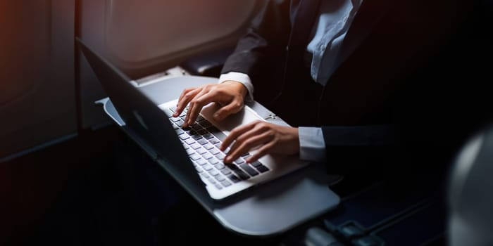 Successful Asian business woman, Business woman working in airplane cabin during flight on laptop computer.