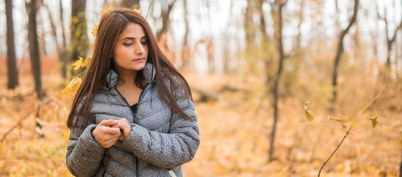 Close-up portrait of a young beautiful confident Indian Asian woman in fall outdoor. Happy and natural smiling female. Generation z and gen z youth