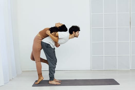 a stretching exercises flexible body acrobatic poses yoga woman and man do gymnastics warm-up
