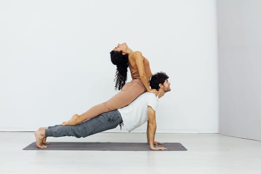 an acrobatics yoga poses woman and man do gymnastics warm-up exercises asana flexible body