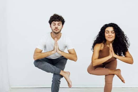 woman and a man do gymnastics warm-up exercises yoga asana poses