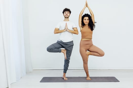 woman and a man do gymnastics warm-up exercises yoga asana poses