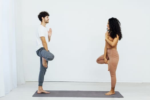 woman and a man do gymnastics warm-up exercises yoga asana poses