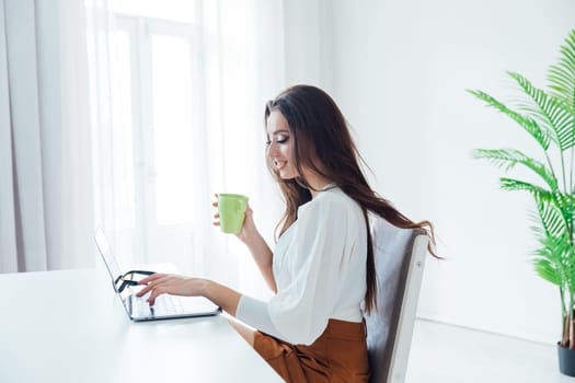 a brunette with a cup at the computer remote work internet conversation online communication