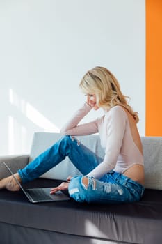 woman with a laptop in the room works remotely online internet communication