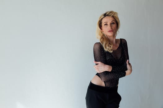 a beautiful blonde in black fashionable clothes on a white background