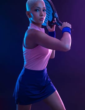 Padel tennis player with racket. Girl teenager athlete with racket on court with neon colors. Sport concept. Download a high quality photo for the design of a sports app or betting site