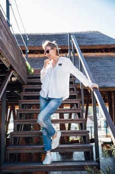 beautiful slender woman stands on the stairs on a walk on the street