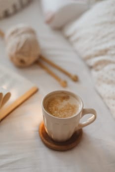 Cozy unmade messy bed with a coffee cup in the morning, breakfast in bed.
