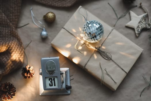 Christmas composition. Gift, fir tree branches, balls on craft paper background. Christmas, winter, new year concept. Flat lay, top view, copy space.