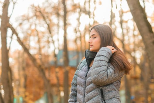 Close-up portrait of a young beautiful confident Indian Asian woman in fall outdoor. Happy and natural smiling female. Generation z and gen z youth