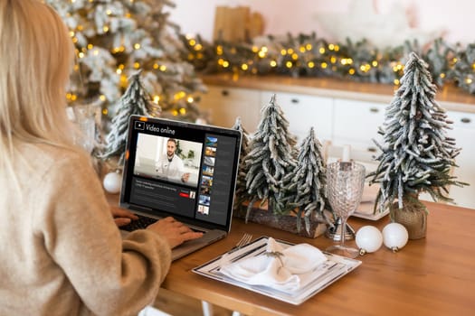 Excited smiling woman have laptop video chat. Young female at home in happy Christmas mood