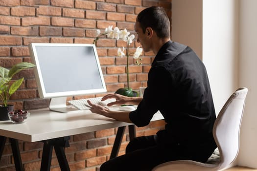 Portrait of happy businessman sitting at office desk.