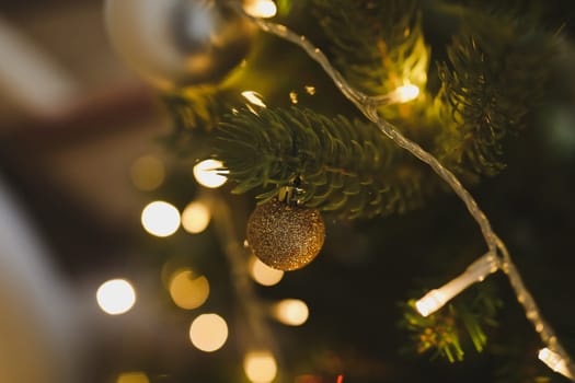 Christmas and New years eve Background. Close up of balls on christmas tree. Bokeh garlands in the background. New Year concept. Decorated Christmas tree on blurred, sparkling and fairy background