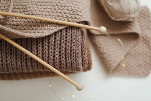 Knitting needles with threads, beige yarn. Hobby for women concept. Knitting accessories.