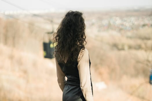 Girl in fall forest. Woman with long curly hair. Beautiful sunlight in the forest. Hair care. Millennial Generation and youth