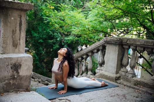 Woman doing yoga exercises outdoors on the bridge