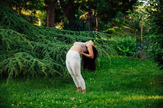 Young asian woman practicing yoga during workout in park