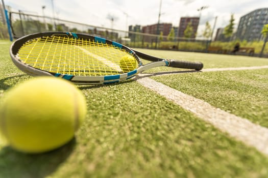 tennis racket with a tennis ball on a tennis court.