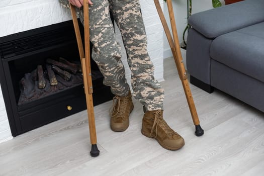 soldier in khaki military uniform on crutches.