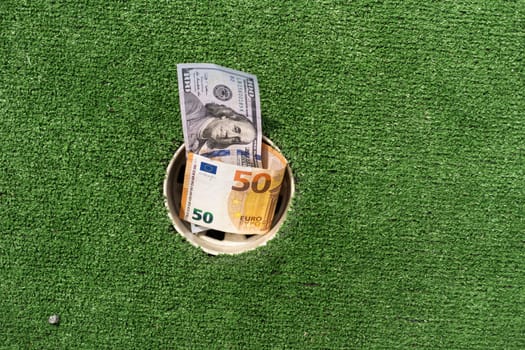 Mini Golf club, money on the artificial grass.