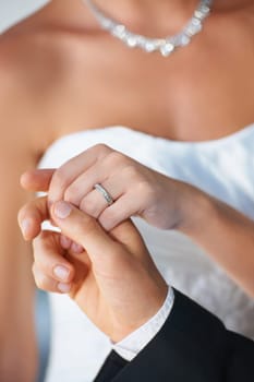 Couple, wedding ring and holding hands hand in marriage with bride at celebration and trust event. Jewelry, loyalty and care with romance and ceremony with love and commitment with woman and man.