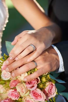 Couple, wedding ring and hand in marriage with bride and ceremony at celebration and trust event. Flower, loyalty and care with romance and holding hands with love and commitment with woman and man.